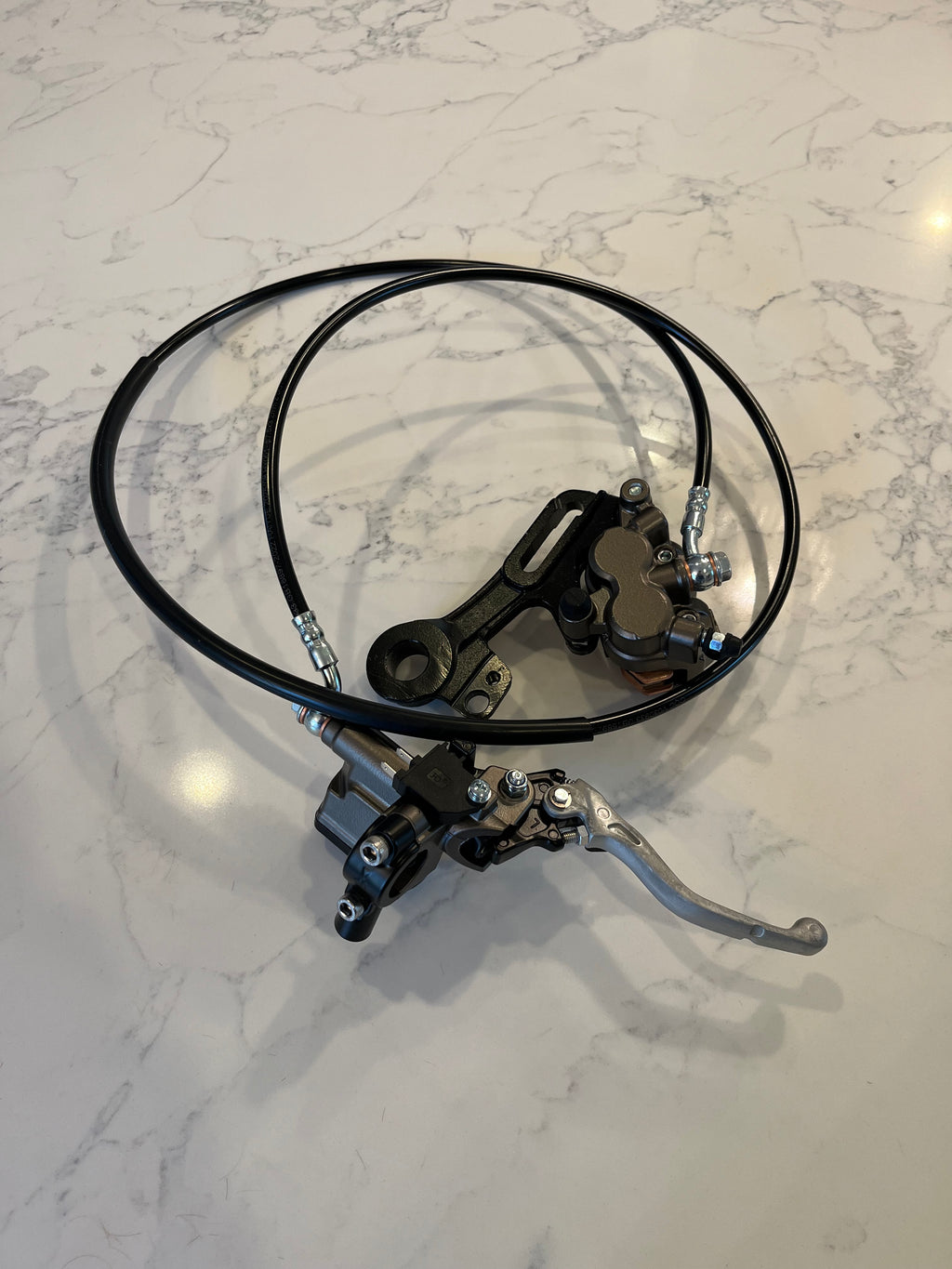 Surron Ultra Bee rear brake assembly — brake line with banjo fittings and caliper