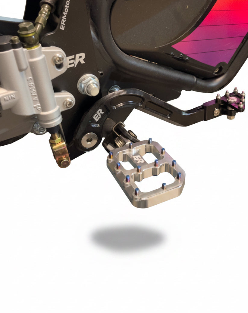ETM RTR super-wide footpegs installed on ETM RTR e-moto, silver chrome CNC aluminum with blue grip screws